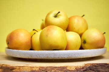 Modern minimalist still life with yellow apples on yellow background