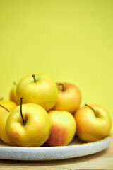 Modern minimalist still life with yellow apples on yellow background