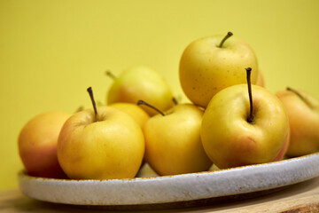 Modern minimalist still life with yellow apples on yellow background
