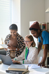 Vertical image of female teacher using laptop in teaching and showing online materials to students...