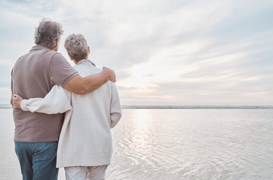 View, back and senior couple by beach to relax on holiday, vacation and romantic adventure together. Marriage, travel and man and woman embrace for affection for bonding, relationship and commitment