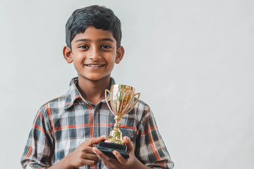 A young Bangladeshi schoolboy beams with pride as he holds a gold trophy, symbolizing his achievement, determination, perseverance, and success. His smile radiates happiness and the joy of accomplishm