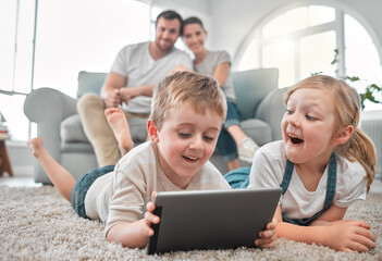 Children, tablet and floor with parents in home for fun game, cartoon entertainment or excited for movie. Family, people and siblings on carpet in living room with tech for digital streaming or relax
