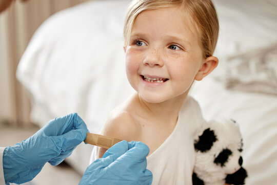 Hands, doctor and girl with bandage for vaccine, health or support with smile in hospital. Pediatrician, child and patient with injection for polio with plaster, service or gloves for care in clinic