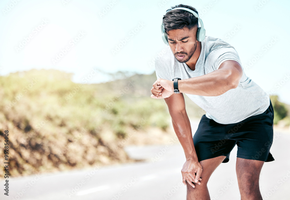 Poster Outdoor, man and headphones with digital watch on break to monitor or tracking health, wellness and wellbeing. Male person, jogging and music with running results, heart rate on exercise app