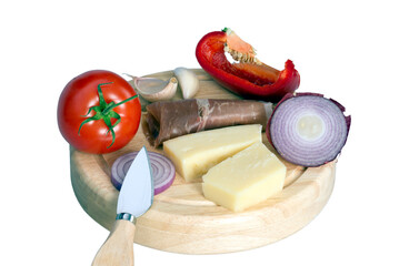 A rustic cheese and charcuterie board with slices of cheese, prosciutto, tomatoes, and red onions isolated on white. Food ideal for a gourmet appetizer or snack.