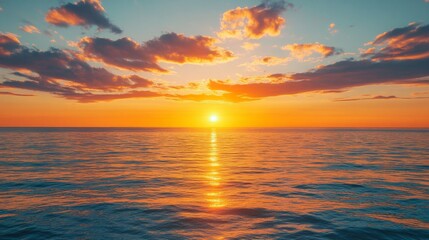 Fototapeta premium A breathtaking golden sunset over calm ocean waters, with vibrant clouds reflecting warm hues across the sky and sea