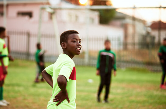 African, boy or soccer player playing on field for practice, workout or exercise in match competition. Grass, tired kid or black child on football pitch for outdoor training, fitness or sports game