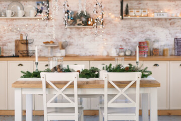 Living room decorated for Christmas with with wooden table, Christmas tree branches and lights.