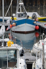 Kleines Fischerboot mit roten Fendern, festgemacht im Hafen von Douarnenez, Frankreich