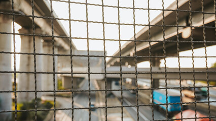 Detailed shot of a metal barrier on an overpass, with a motorbike passing by in the blurred...