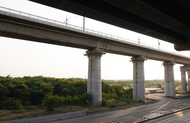 Concrete overpass towering over lush greenery, blending urban structure with natural landscape