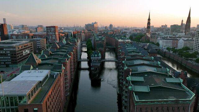 Drone view of Old red-brick buildings in Speicherstadt along a canal. Flight through the Warehouse district in Hamburg, Germany.