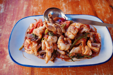 A close-up of a delicious plate of stir-fried squid served with vibrant vegetables in a spicy sauce.