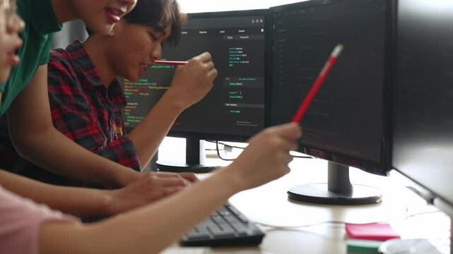 Slow motion back end software developer engineer for computer programming working together on debugging writing computing code, solving complex algorithms display on monitor in office. Burgeoning
