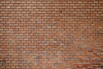 A high-resolution image of a rustic red brick wall. 