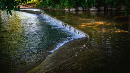 Tranquil river flow and sunray reflections on the water at Sugar House Park in Salt Lake City,...