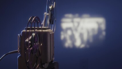 A classic 8mm film projector running film and projecting a movie onto a wall. The beam of light is visible, creating a nostalgic atmosphere perfect for retro or vintage-themed projects.