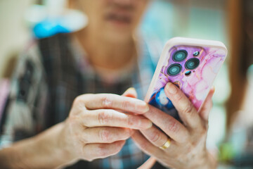 スマートフォンを持つシニア女性の手元