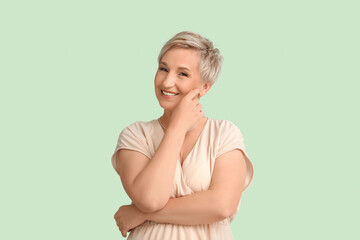 Mature blonde woman on green background