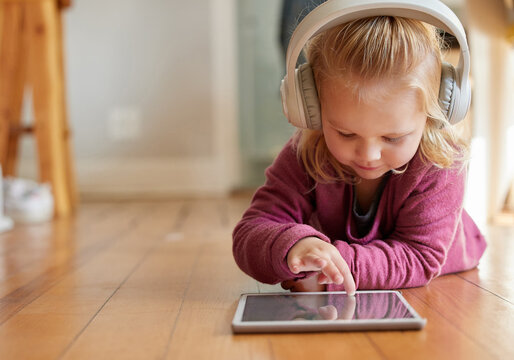 Child, tablet and digital game with web education, fun and youth development on home floor. Young girl, technology and school learning app with online video watching, toddler headphones and mockup