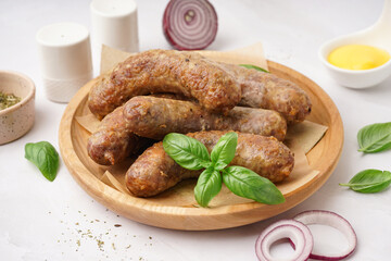 Plate of tasty homemade sausages on grey background