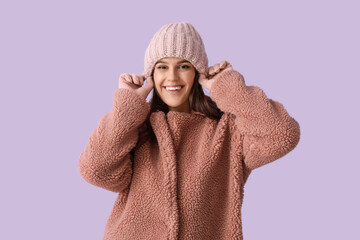 Young woman in teddy coat on lilac background