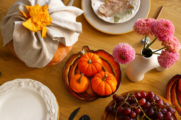 Autumn table setting with pumpkins, grapes and flowers