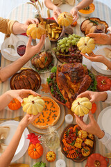 Group of young friends having dinner at festive table on Thanksgiving Day, closeup