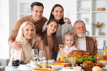 Happy family having dinner at festive table on Thanksgiving Day