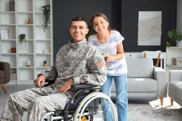 Soldier in wheelchair with his little daughter at home. Veterans Day celebration