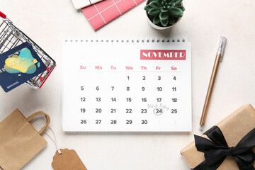 Beautiful composition with calendar page of November 2023, shopping cart and gift box on white background. Black Friday concept