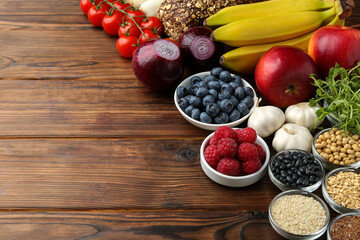 Different fresh products on wooden table, space for text. Source of prebiotics