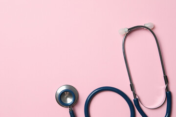 Stethoscope on pink background, top view. Space for text