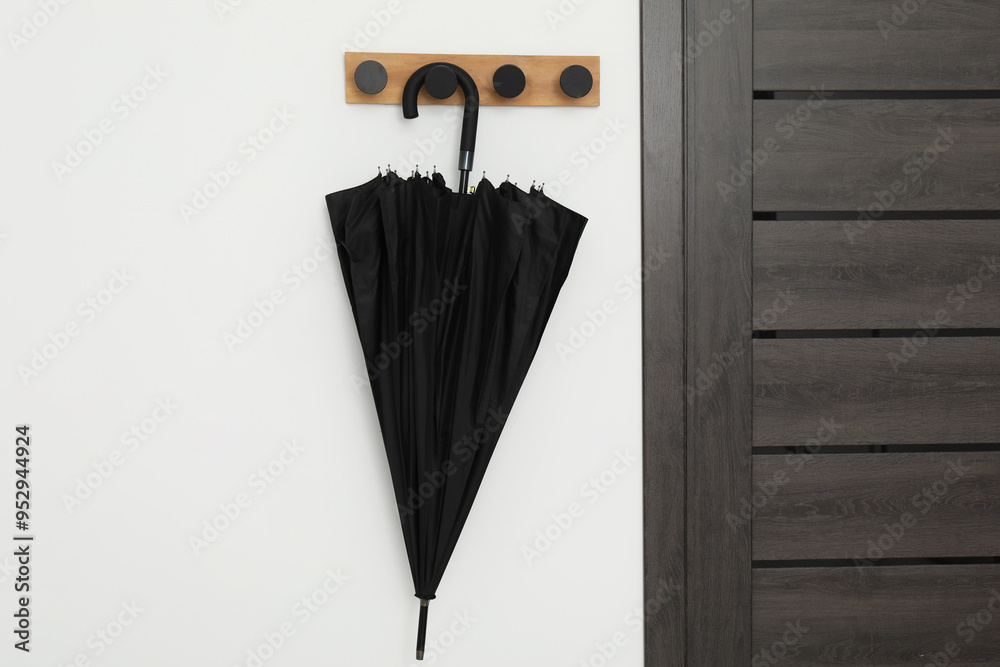 Wall mural black umbrella on coat rack in hallway