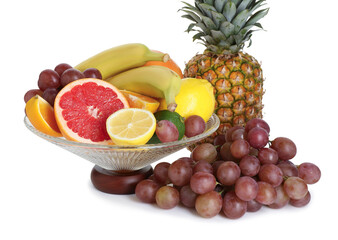 Glass vase with different fresh fruits isolated on white