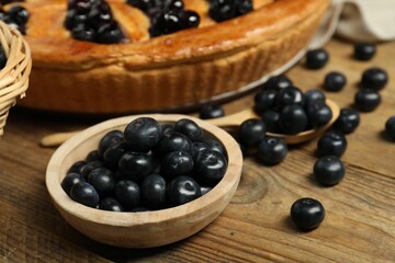 Fresh blueberries and tasty homemade berry pie on wooden table, closeup