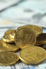 Many euro coins on dollar banknotes, closeup