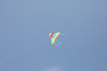 One colorful kite flying in blue sky