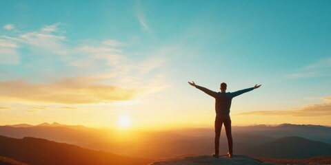 Fototapeta premium A person stands on a mountain peak, arms open wide, embracing the beautiful sunset and horizon view, symbolizing freedom and joy.