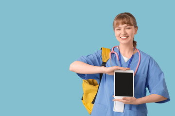 Female medical intern with tablet computer on blue background
