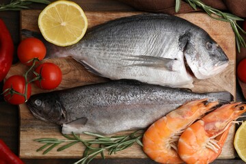 Fresh raw sea food and products on wooden table, flat lay