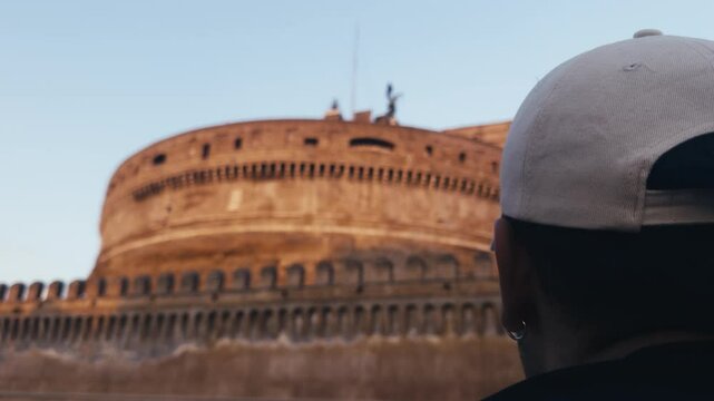 un ragazzo che guarda castel'santangelo da dietro dal lato sinistro