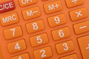 a close-up of an orange calculator, highlighting the numerical keys and basic arithmetic functions...