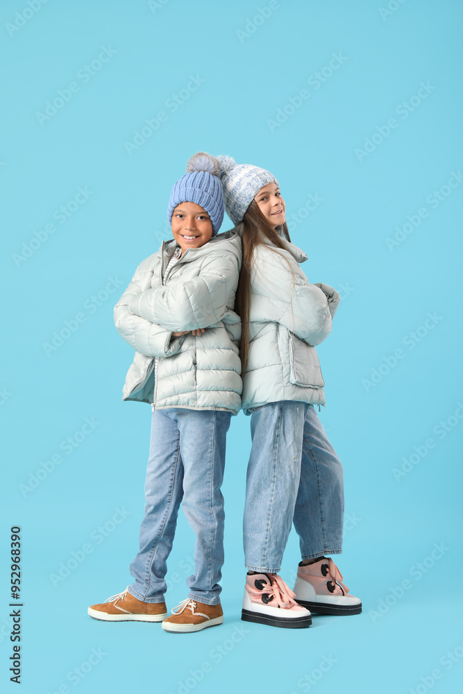 Wall mural cute little happy children in winter clothes on blue background