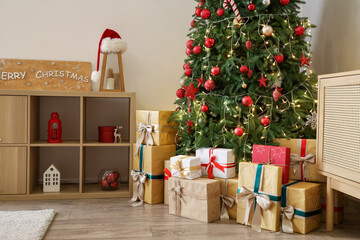 Interior of living room with glowing Christmas tree, presents and shelf unit