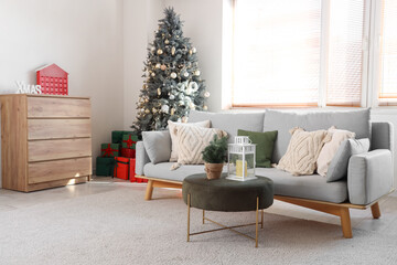 Interior of light living room with Christmas trees and sofa