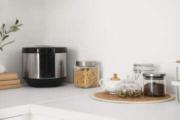 Multicooker with jar of pasta on counter in kitchen