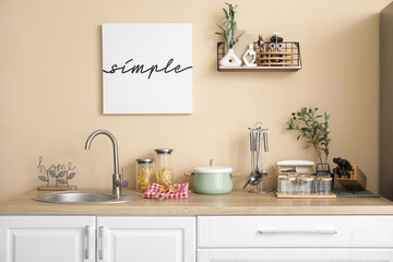 Interior of kitchen with counters, shelf and utensils