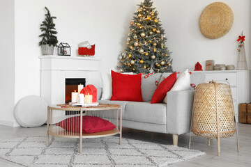 Interior of living room with sofa, fireplace and burning candles